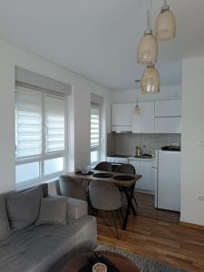 a living room with a couch and a table and a kitchen at Apartman Dolce Vita Sokobanja in Soko Banja
