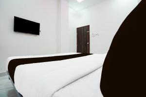 KhāpriにあるHotel O Hybridのテレビ付きの客室の白いベッド1台