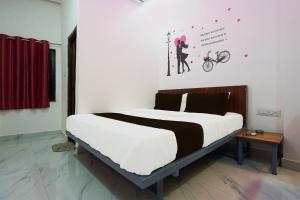 KhāpriにあるHotel O Hybridのベッドルーム1室(大型ベッド1台、自転車を持つ女性1名付)