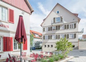an umbrella and tables and chairs in front of a building at Altes Bräuhaus, Ferienwohnungen und Apartments in Gaildorf in Gaildorf