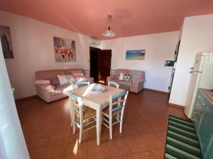 a kitchen and living room with a table and chairs at Charming apartment with dreamy terrace in Arzachena +56 photos