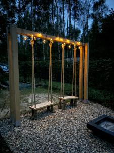 a swing set with lights and two benches at DOMEK W BRZOZACH JacuzziBalia w cenie Las Blisko Jeziora in Lgiń