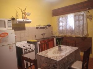 a kitchen with a table and a stove and a refrigerator at CHE Camilo in Tanti +1 photo