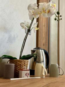 una mesa con un jarrón con flores blancas. en APARTAMENT - Torino Home Living, en Turín