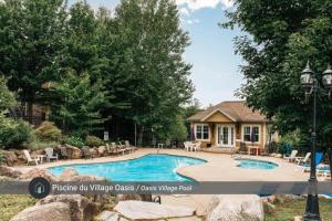 a swimming pool in front of a house at La Halte Mont-Blanc Ski in out in Saint-Faustin