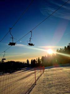 a ski lift with the sun setting in the background at Apartment - Golden Fox 18 - Pohorske terase in Pohorje +17 photos