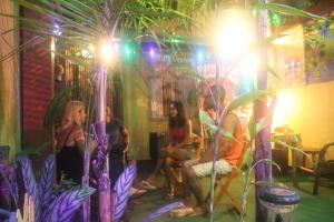 乌巴图巴Ubatuba Wild Surf Hostel的一群人坐在棕榈树的房间