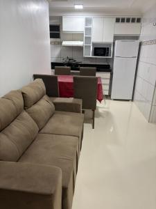 a living room with a couch and a kitchen at Central apartamento Flor de Cheiro in Fortaleza +6 photos