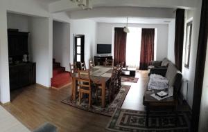 a living room with a table and a dining room at Pensiunea Zina in Tisău