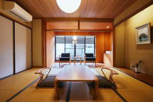 a dining room with a table and chairs in a room at TSUCHIYA Kinosaki onsen in Toyooka