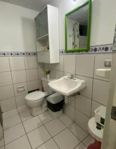 a white bathroom with a toilet and a sink at Departamento amoblado in Puente Piedra