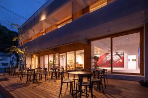 a restaurant with tables and chairs on a deck at TSUCHIYA Kinosaki onsen in Toyooka