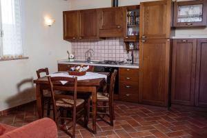 Il comprend une cuisine équipée d'une table, de chaises et d'une cuisinière. dans l'établissement Agriturismo Cupido, à Montiano