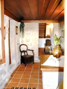 Zimmer mit einem Tisch und einem Stuhl auf einem Fliesenboden in der Unterkunft Charming house with fireplace, mountain view, Ponte da Barca in Pedras de Moledo