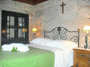 ein Schlafzimmer mit einem Bett mit einem Kreuz an der Wand in der Unterkunft Charming house with fireplace, mountain view, Ponte da Barca in Pedras de Moledo