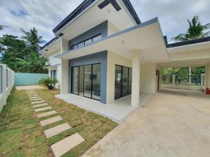 a large white house with a lot of windows at Villa Emee Nora in Panglao Island