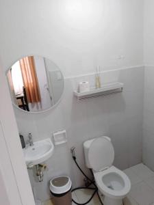 a white bathroom with a toilet and a sink at Casa de Ligaya San Pablo in San Pablo