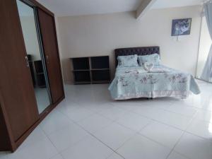 a bedroom with a bed with a blue comforter at Suítes Bisi in Cabo Frio