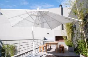 a white umbrella on a patio with a table and chairs at Funky & Stylish Apartment Palermo in Buenos Aires