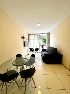 a living room with a glass table and chairs at Apartamento pé na areia em Praia de Rio das Ostras in Rio das Ostras +43 photos