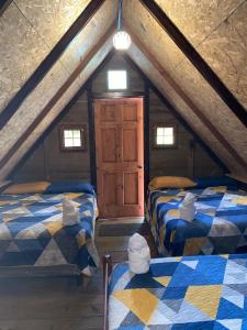 a attic room with two beds and a window at Casa Santa Teresita - Cabaña triple in Sanarate +8 photos