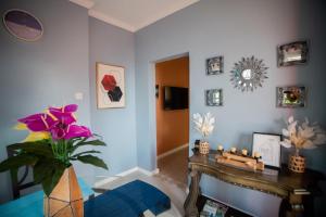 a living room with a table and flowers on the wall at Buena Vista SLC in Vieux Fort