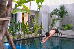 a man is doing a pose in a pool at veHaa BOUTIQUE HOTEL in Phnom Penh