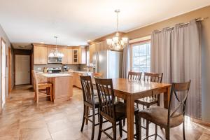 a kitchen and dining room with a wooden table and chairs at Mountain View-Steam Shower-2 Tier Patio- King Bed in Northampton