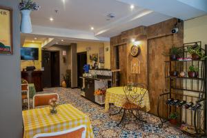a room with a table and chairs and a kitchen at Ronda Hotel Boutique by Chat Noir in Cuenca