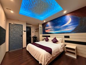 a bedroom with a bed with a painting on the wall at Venus Boutique Hotel in Malacca