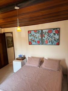 ein Schlafzimmer mit einem Bett und zwei Gemälden an der Wand in der Unterkunft Winterville Gravatá in Gravatá + 22 Fotos