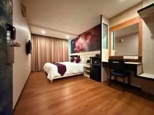 a hotel room with a bed and a desk and a computer at Venus Boutique Hotel in Malacca