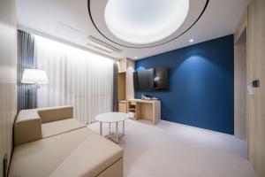 a living room with a couch and a blue wall at Hound Hotel Gwangju Cheomdan in Gwangju