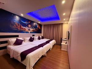 a bedroom with two beds and a blue ceiling at Venus Boutique Hotel in Melaka