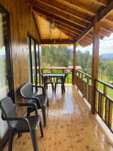a screened in porch with tables and chairs on it at Cabaña Loto - Paipa in Paipa +20 photos