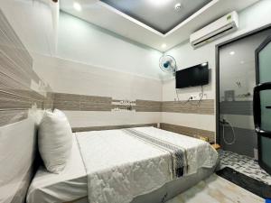 a bedroom with a bed and a tv in it at Ông 5 House in Can Tho