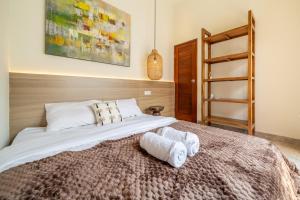 a bedroom with a large bed with towels on it at Villa Five Smile Ungasan in Badung