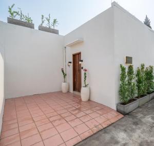 a courtyard with white walls and potted plants at Villa Five Smile Ungasan in Badung
