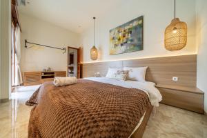a bedroom with a large bed and pendant lights at Villa Five Smile Ungasan in Badung