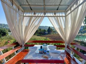 a table with white dishes on it with a view at น้ำหนาวโฮมสเตย์เขาค้อ in Phetchabun