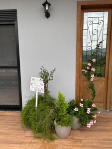 a sign in front of a door with potted plants at Refúgio nascer das águas in Gravatal