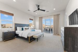 a bedroom with a bed and a tv and windows at Villa #02 at Bloomington Country Club condo in St. George