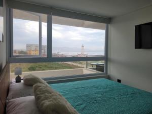 Departamento Laguna del Mar في لا سيرينا: غرفة نوم بها سرير ونافذة كبيرة