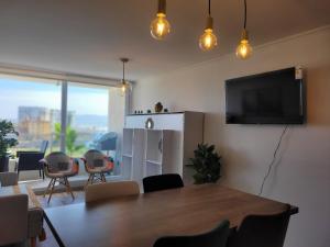 ein Wohnzimmer mit einem Tisch und einem Flachbildfernseher in der Unterkunft Departamento Laguna del Mar in La Serena