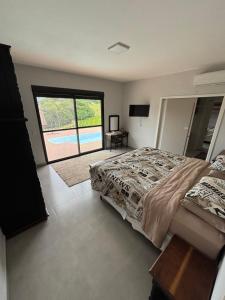 a bedroom with a bed and a view of a pool at Refúgio nascer das águas in Gravatal