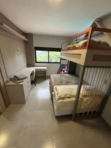 a bedroom with a bunk bed and a desk at Refúgio nascer das águas in Gravatal