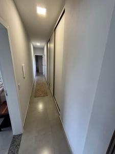 a long hallway with white walls and a carpet at Refúgio nascer das águas in Gravatal