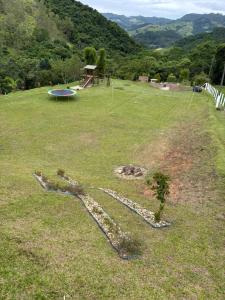 a rock pathway in a field with a frisbee at Refúgio nascer das águas in Gravatal