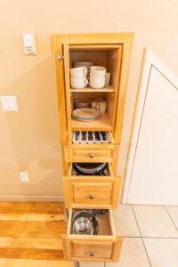 a wooden hutch with dishes and bowls in it at BANFF WOODS LODGE in Canmore +33 photos