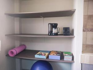 a shelf with a coffee maker and books on it at My house is your house in Manta